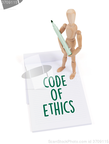 Image of Wooden mannequin writing - Code of ethics