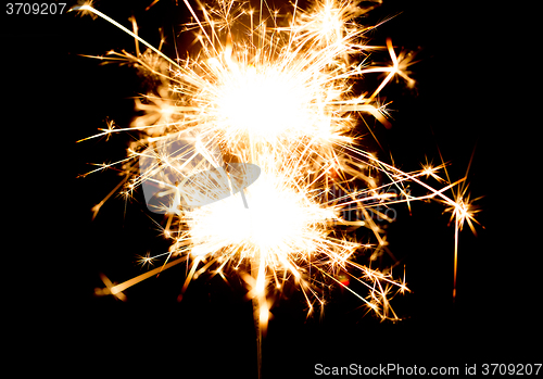 Image of sparkler or bengal light burning over black