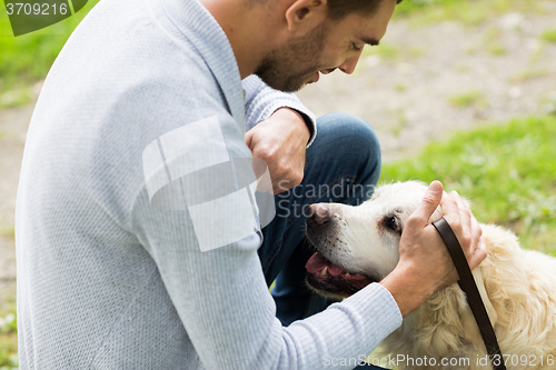Image of close up of man with labrador dog outdoors