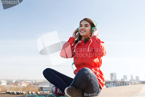 Image of happy young woman in headphones listening to music