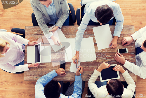 Image of close up of business team with papers and gadgets