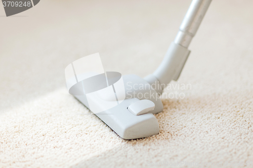 Image of close up of male hoovering carpet