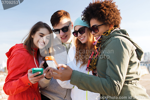 Image of smiling friends with smartphones