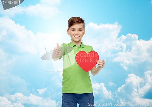 Image of happy boy showing red heart shape and thumbs up