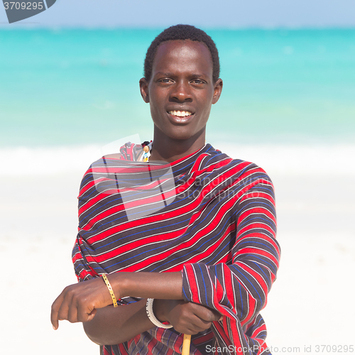 Image of Traditonaly dressed black man on beach. 