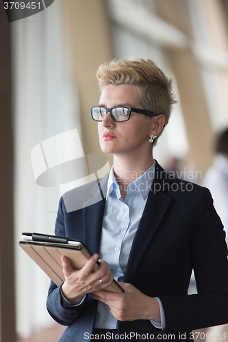 Image of business woman  at office with tablet  in front  as team leader