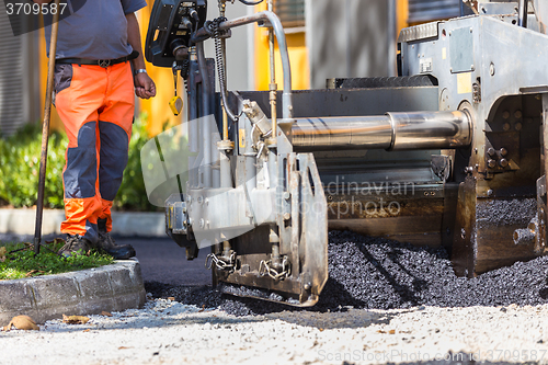 Image of Asphalt surfacing manual labor.