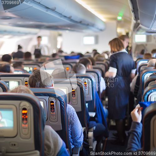 Image of Stewardessand passengers on commercial airplane.