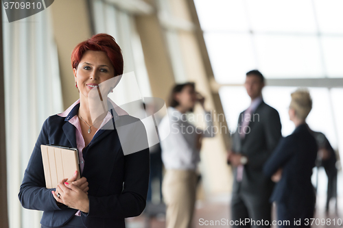 Image of business woman  at office with tablet  in front  as team leader