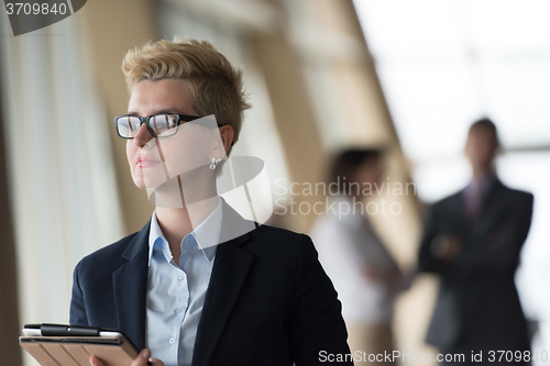 Image of business woman  at office with tablet  in front  as team leader