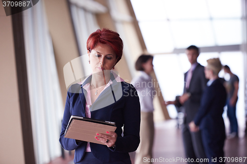 Image of business woman  at office with tablet  in front  as team leader