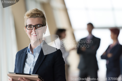 Image of business woman  at office with tablet  in front  as team leader