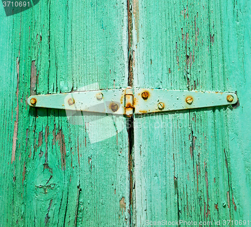 Image of in the old wall a hinged window green wood and rusty metal