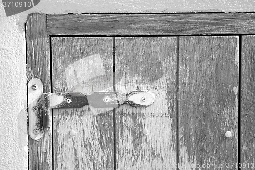 Image of in the old wall a hinged window blue wood and rusty metal