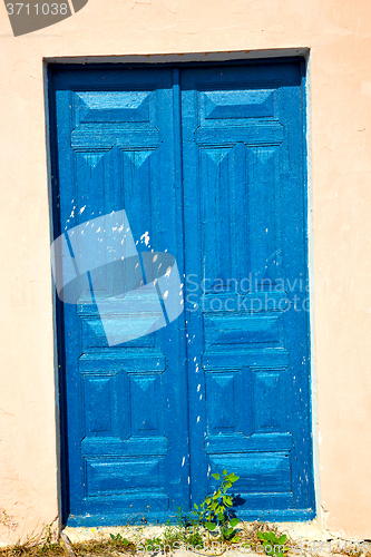 Image of blue door in antique village    white wall