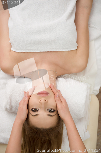 Image of woman getting face and head  massage in spa salon