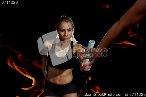 Image of double exposure athletic runners passing baton in relay race