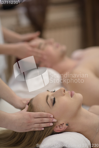 Image of relaxed young couple getting massage in spa