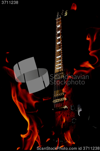 Image of double exposure  electric guitar and fire