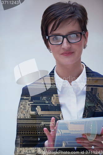 Image of double exposure of business woman working on tablet computer