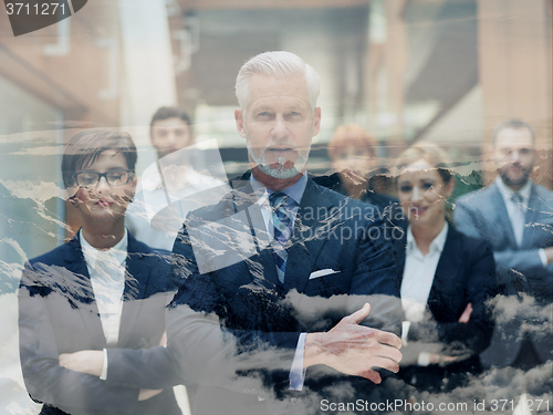 Image of double exposure of senior business man with his team at office