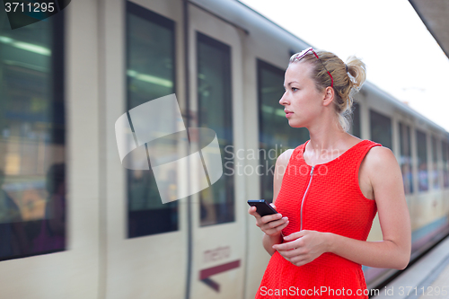 Image of Young woman on platform of railway station.