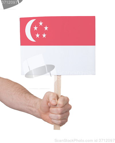 Image of Hand holding small card - Flag of Singapore