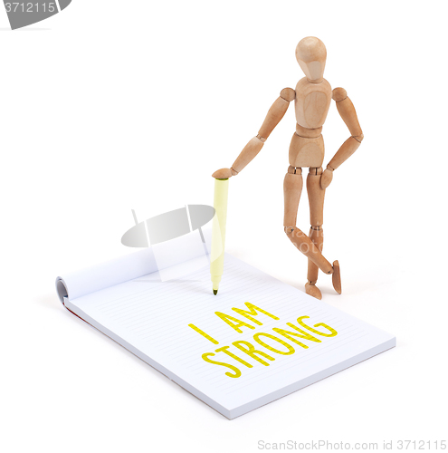 Image of Wooden mannequin writing - I am strong