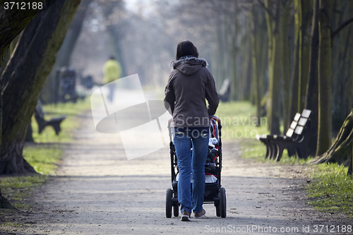 Image of woman with pram in autumnal park