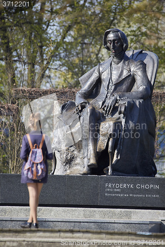 Image of Young woman standing near Chopin statue