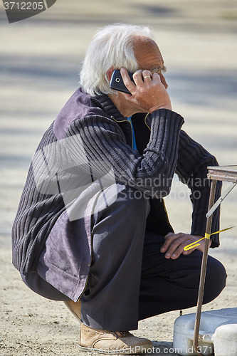Image of Senior man speaking on smartphone