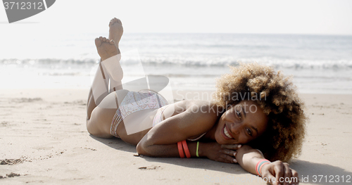 Image of Woman In A Swimsuit Relaxing On The Sand