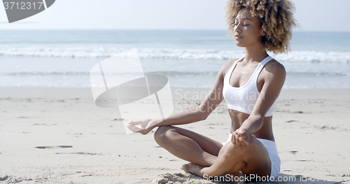 Image of Woman Meditating On Beach In Lotus Position