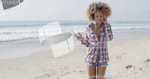 Image of Young Woman Listening To Music At The Beach