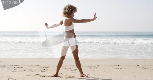 Image of Woman Practices Yoga On A Beach