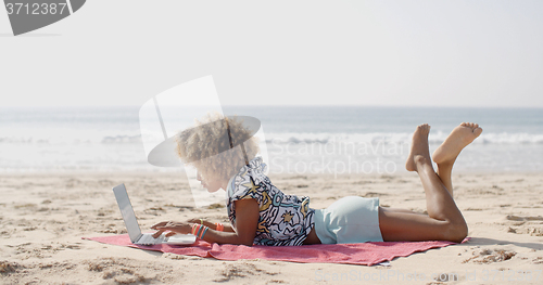 Image of Happy Woman Typing On Laptop at Beach