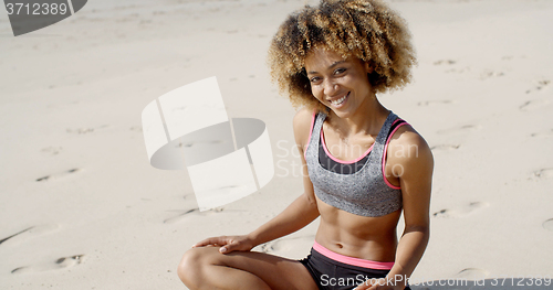 Image of Woman In Sporty Outfit Sits On The Sand