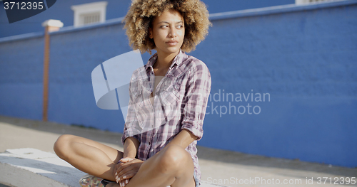 Image of Woman With Smartphone Sitting On Stone Wall