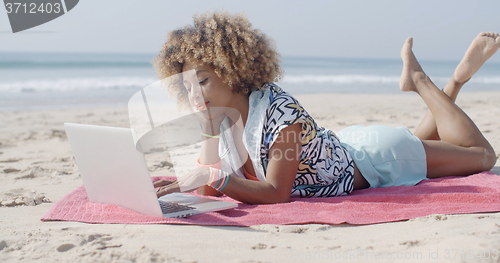 Image of Woman On The Beach Using A Computer