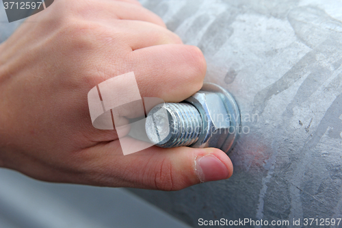 Image of metal nut to the bolt by hand wound in the pipe.