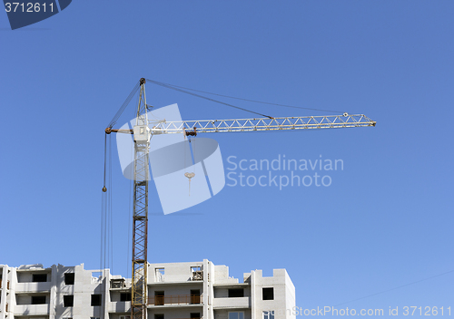 Image of Industrial landscape, building crane against the blue sky