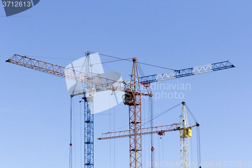 Image of Industrial landscape with silhouettes of cranes on the sky backg