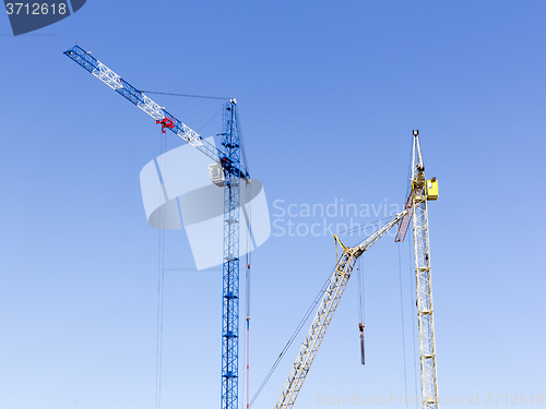 Image of Industrial landscape with silhouettes of cranes on the sky backg