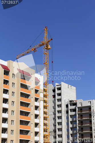 Image of Industrial landscape, building crane against the blue sky