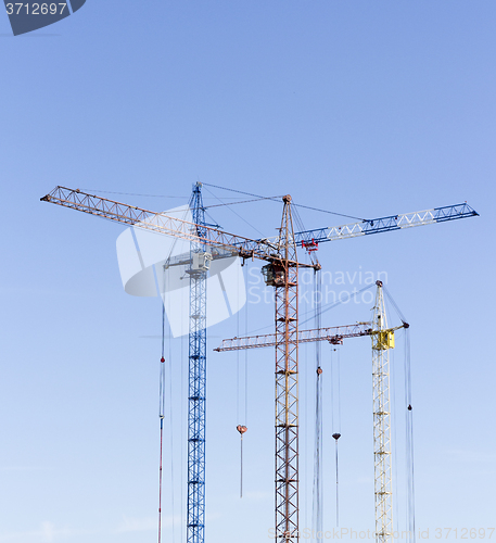 Image of Industrial landscape with silhouettes of cranes on the sky backg