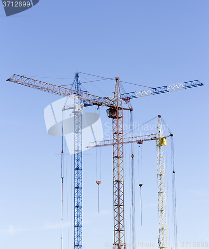 Image of Industrial landscape with silhouettes of cranes on the sky backg