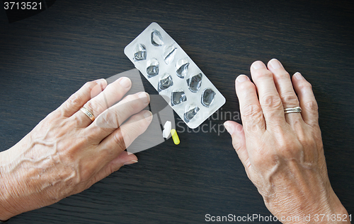 Image of Elderly person taking medication