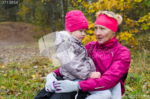 Image of Woman with girl doing aerobics in the autumn park