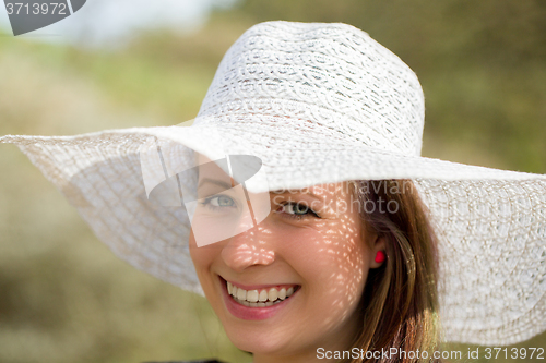 Image of cheerful fashionable woman with hat