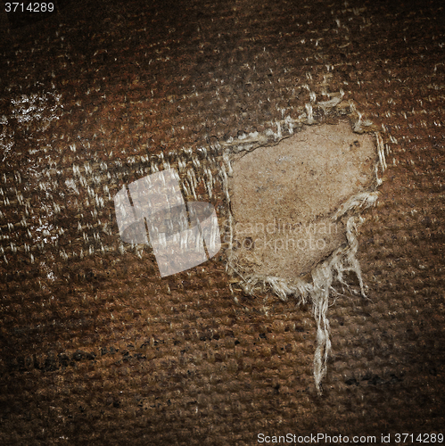 Image of Detail (damage) of an old canvas suitcase, close-up